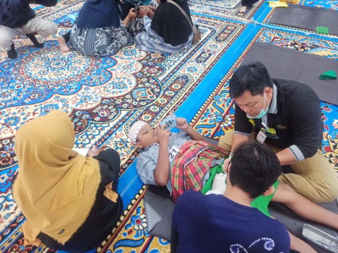 
 Alihkan Rasa Sakit Sunat, Salah Satu Peserta Sunat Massal Asyik Main Game