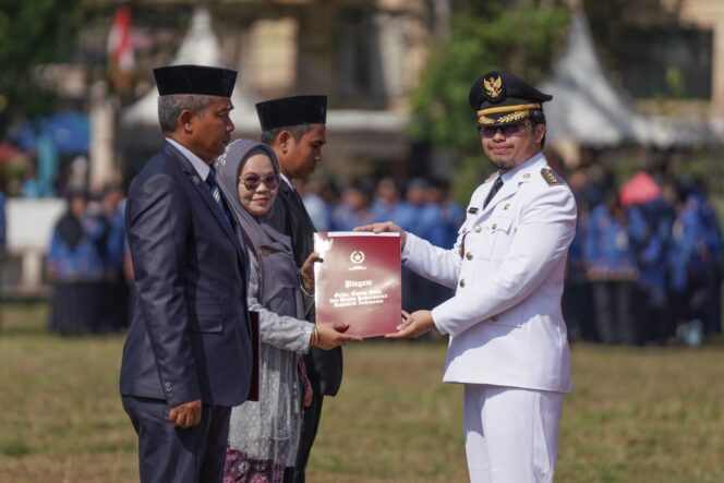 
 Bupati HST, H Aulia Oktafiandi menyerahkan penghargaan Satyalencana Karya kepada 3 PNS usai Upacara Pengibaran Merah Putih di Lapangan Dwi Warna Barabai, Kamis (17/8/2023) pagi.
